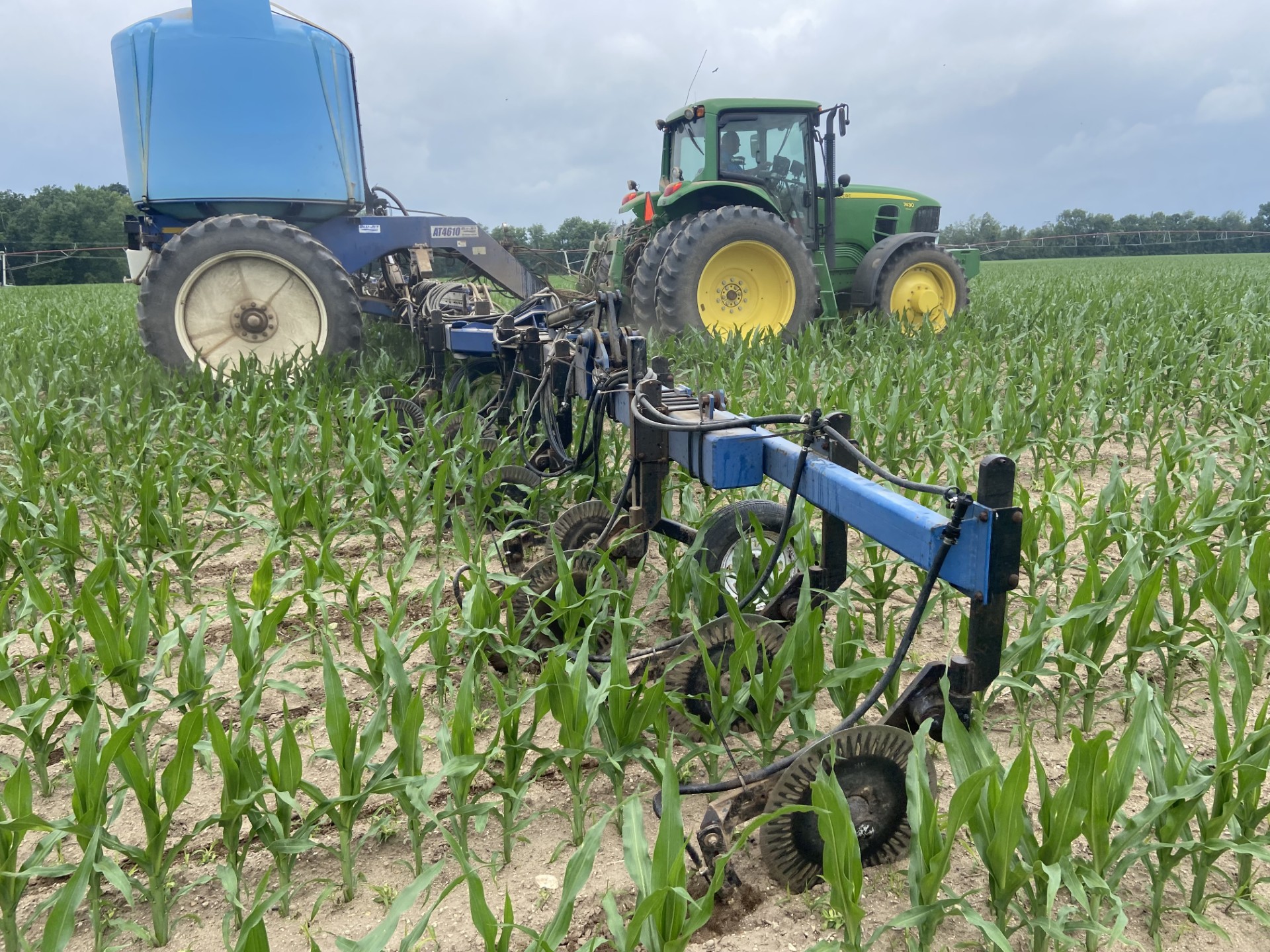 A tractor applying side dress nitogren to a corn field.